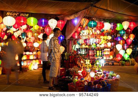 Vietnamese man selling colorful lanterns at the market street of Hoi An
