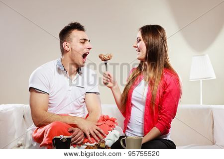 Smiling Woman Feeding Happy Man With Cake.