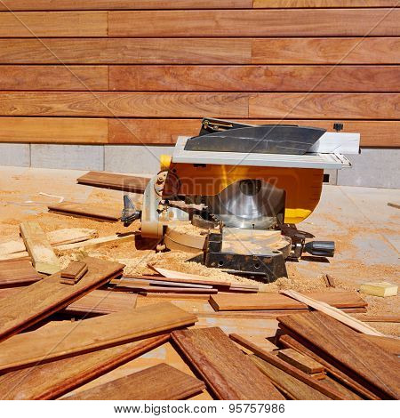 Ipe wood fence installation with carpenter table circular saw and sawdust