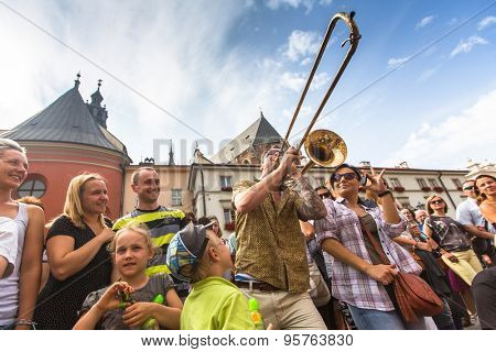 KRAKOW, POLAND - JUL 12, 2015: Participants at the annually (July 9-12) 28th International Festival of Street Theatres - Orchestre International du Vetex (Belgium/France) in the Main Square of Krakow.