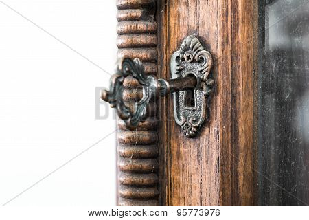Vintage keyhole with key on vintage wooden cabinet with white background
