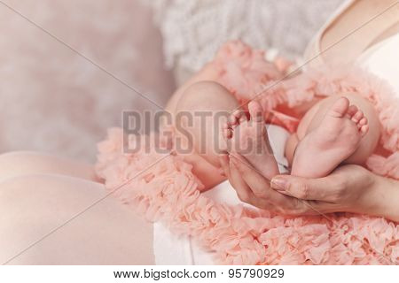 Mother Holding Feet Of Her Daughter.
