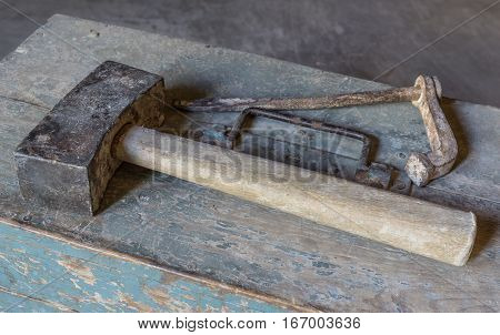 Chisel and hammer over old tools for housework, vintage look, over old wooden toolbox, timeworn paint