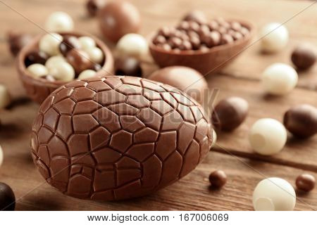 Chocolate Easter eggs and sweets on brown wooden background