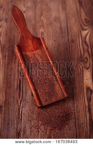 grated 100% dark chocolate flakes on vintage  wooden grate,   shallow DOF