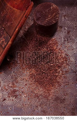 grated 100% dark chocolate flakes on vintage  wooden grate,   shallow DOF