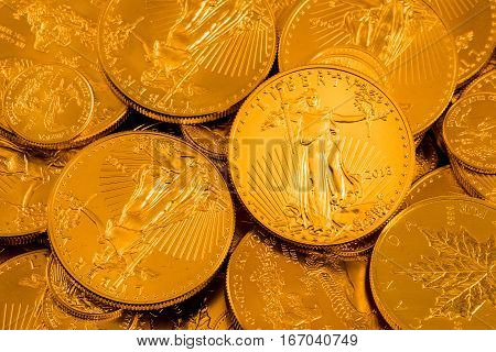 Gold Eagle one ounce coin against a golden background of other coins with focus on the Liberty symbol