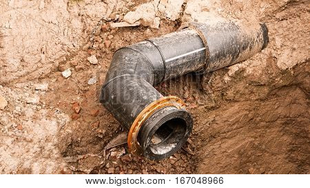Ditch with open modern PVC water large diameter pipe in its side, vontage color.