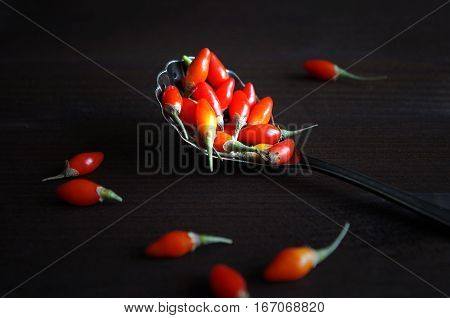 fresh healthy goji berries in front of a brown wooden background
