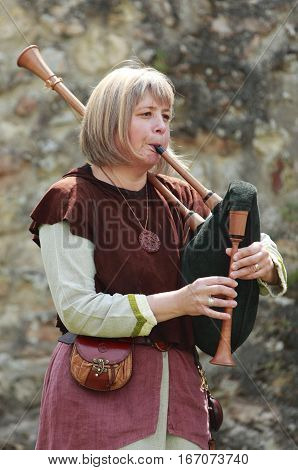 Nogent le Rotrou,France-May16th,2010:A woman wearing traditional medieval clothes play a bagpipe during the 