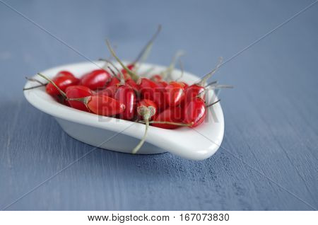 fresh undried goji berries in front of a blue wooden background