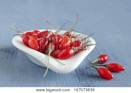 fresh undried goji berries in front of a blue wooden background
