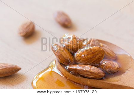 honey coating almond in wood spoon with copy space