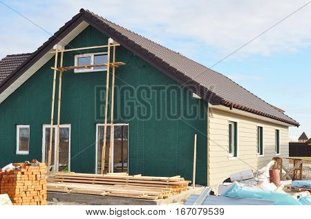 Building New House with Plastic Siding and Insulation Membrane on House Exterior Wall. House Construction