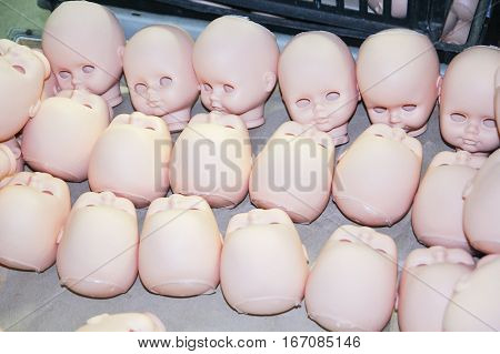 few heads of dolls without eyes are in the box