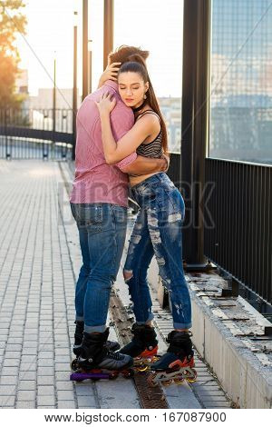 People on rollerblades hugging. Couple on city background. Hold me tighter.