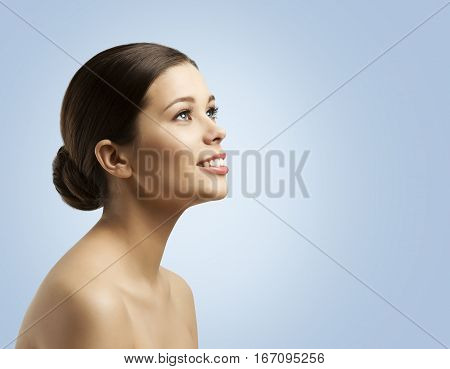 Woman Face Side View Bun Hair Fashion Model Beauty Makeup and Hairstyle over Blue