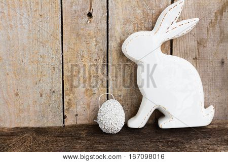 Easter eggs hunt - bunny with egg on wooden background