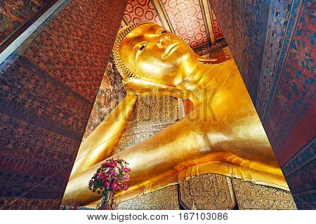Golden statue of the Reclining Buddha in Wat Pho (Pho Temple) in Bangkok Thailand.