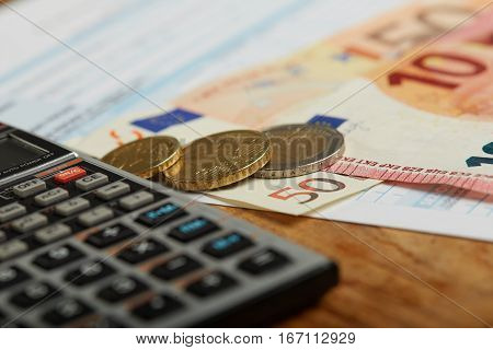 handful of coins with calculator close up