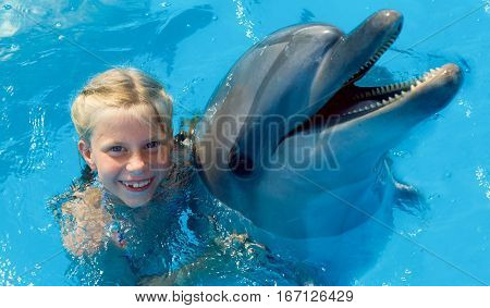 Happy child and dolphins in blue water. Dolphin Assisted Therapy