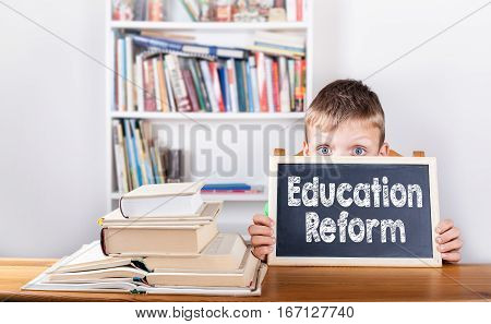 Education Reform. Boy holding chalkboard in office.