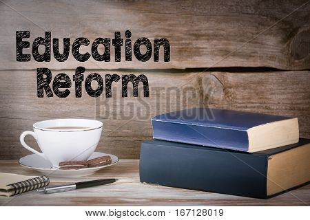 Education Reform. Stack of books on wooden desk.