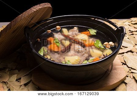 Clear oxtail soup on leaf background black background