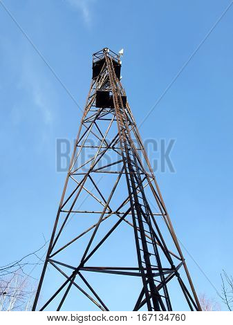 Triangulation mark on mountain top in summer time. Cell tower and radio antenna