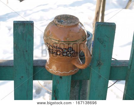 ceramic glechik upside-down weighs on the fence