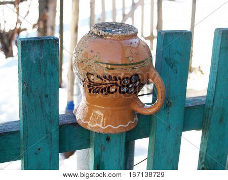 ceramic glechik upside-down weighs on the fence