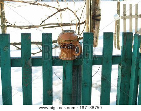 ceramic glechik upside-down weighs on the fence