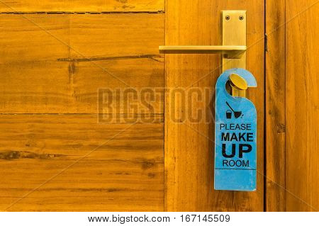 Close-up of please make up room sign on door knob in hotel