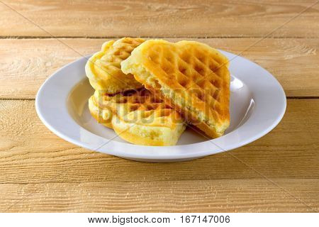 Waffles on a white plate and wooden background