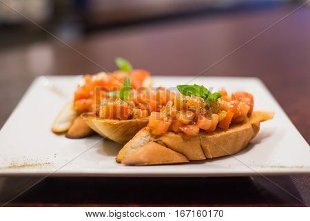 Fried toast with salad decorated with basil on a white plate