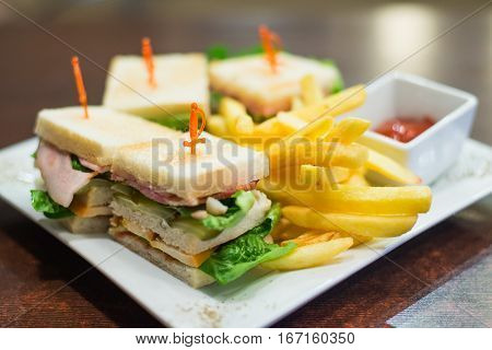 Mini sandwiches with fried fries and sauce on a white plate