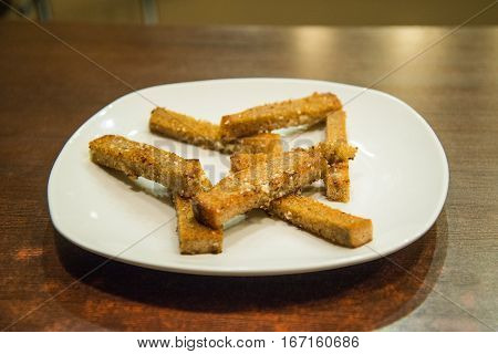 fried croutons on a white plate with garlic