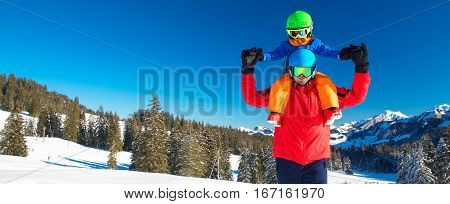 Little boy having fun with his caucasian attractive father during skiing in Alps.
