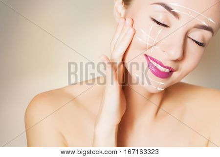 beautiful woman face with surgery marks on beige
