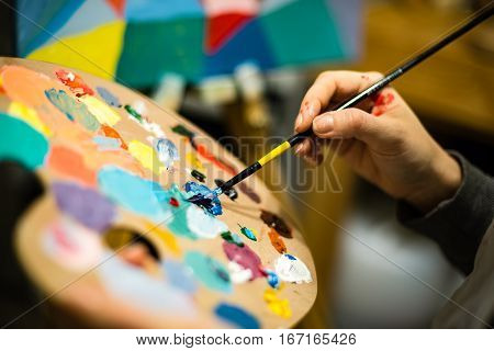 Artist Painting With Acrylic Colors And Mixing Tones
