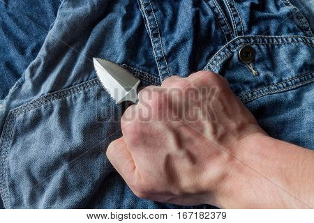 Neck Knife On Jeans Background In Hand.