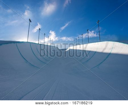 Empty winter snow halfpipe on a sunny day