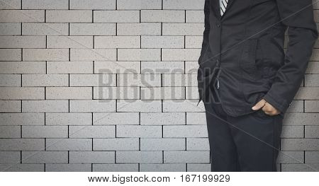 businessman standing on brick wall background with copy space