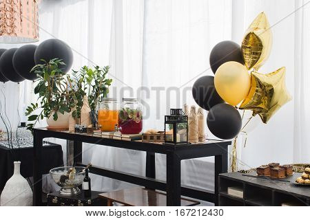 Beautiful restaurant with nice interior. A lot of balloons near the tabble. Drinks are varicoloured