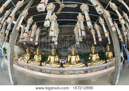 UBON RATCHATANI,THAILAND -JANUARY 17,2017 : Row of golden Buddha in the cave of Wat Tham Khuha Sawan temple is located on a high cliff above the river Mekong .Khong Chiam District , Ubon Ratchathani, Thailand.