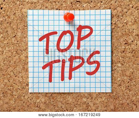 The words Top Tips in red text on a piece of square graph paper pinned to a cork notice board as a reminder