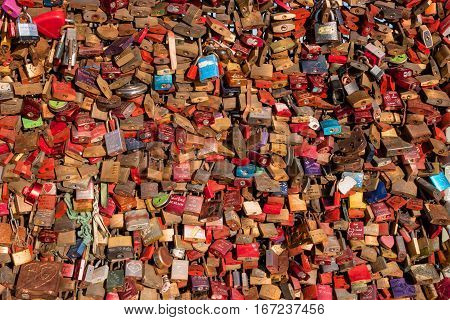 Cologne, Germany - January 19, 2017: A cluster of love locks on Hohenzollern Bridge. As proof of their love couples fix padlocks to the bridge railings and throw the key into the river below.