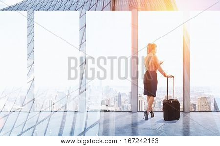 Rear view of a businesswoman with luggage standing in an office with panoramic windows. 3d rendering. Mock up. Toned image. Double exposure.
