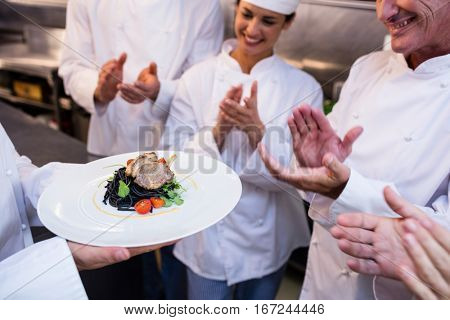 Team of chefs applauding in the kitchen