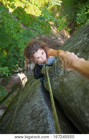 Climber Helping Female Climber To Reach A Peak Of Mountain